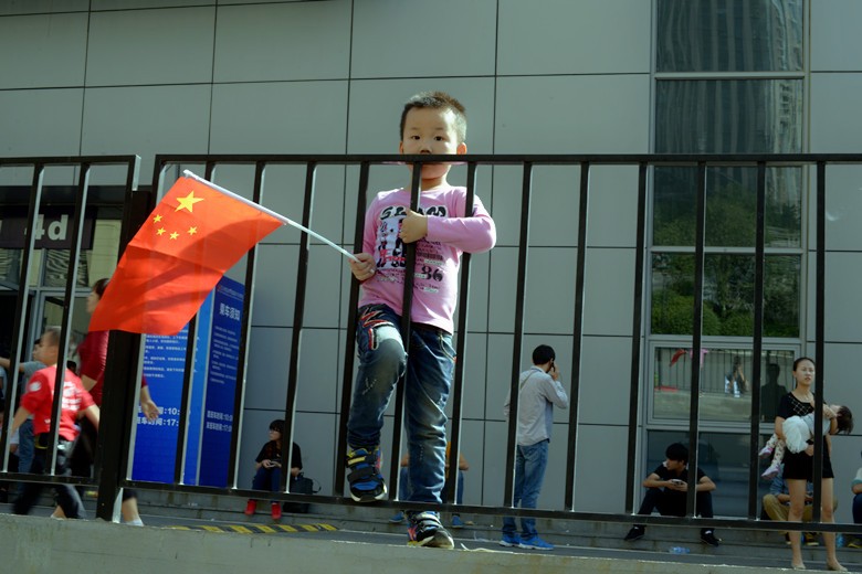 拿着五星红旗等着爸爸的新车